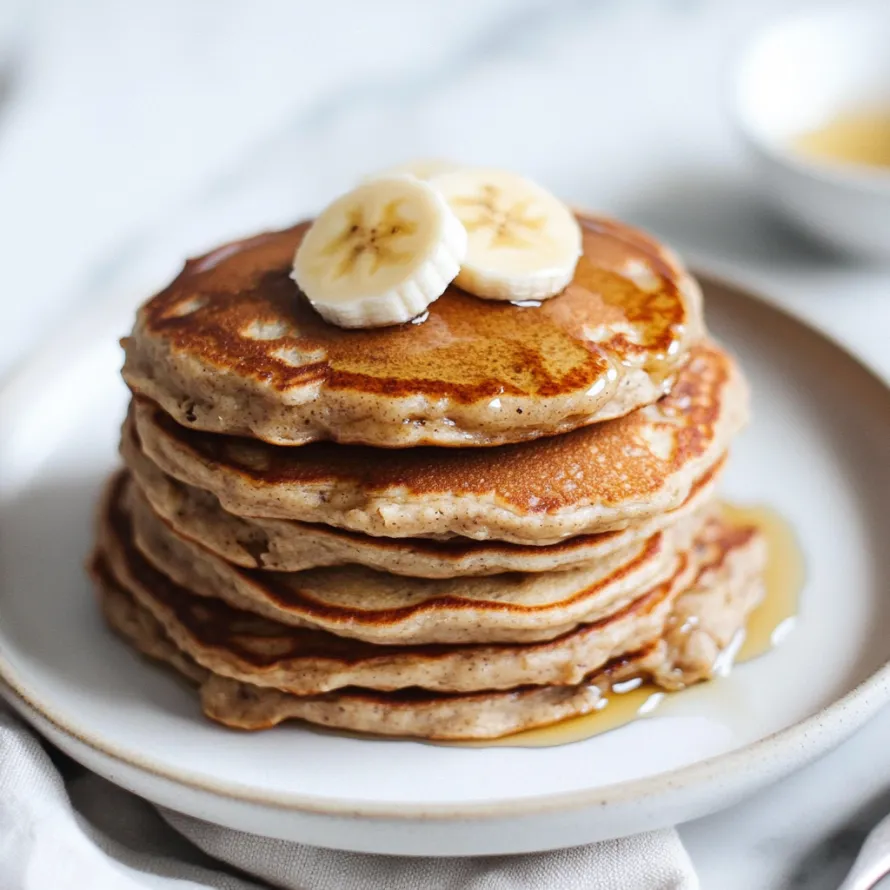 A stack of pancakes with bananas on top.