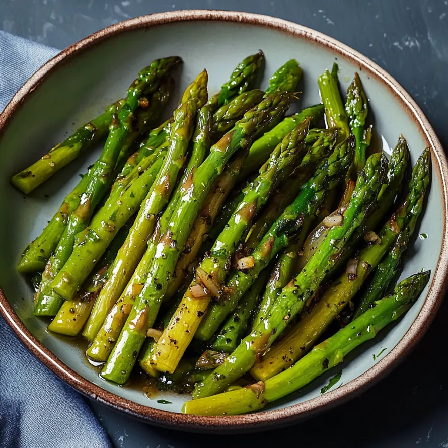 A bowl holding asparagus with a tasty sauce.